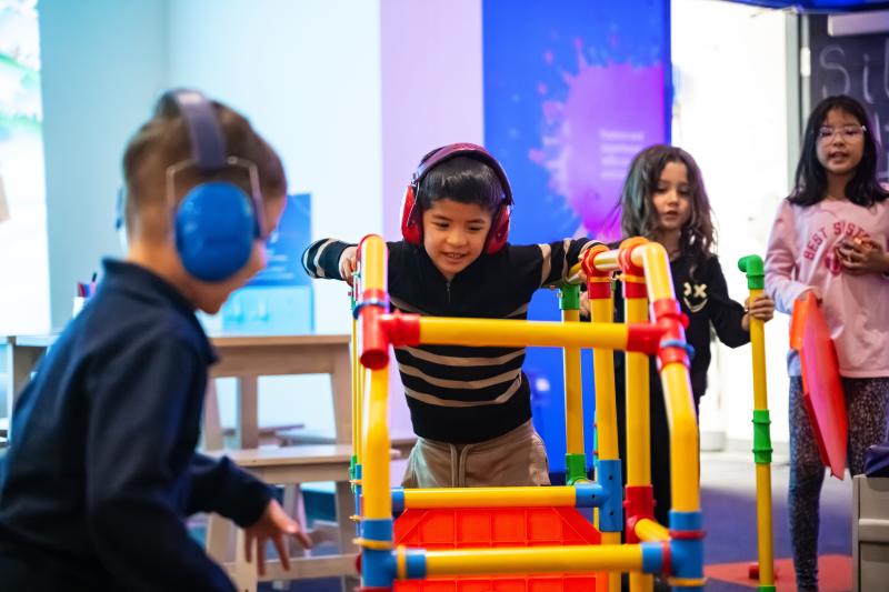 Boys wearing noise-reducing headphones while playing at idea Museum